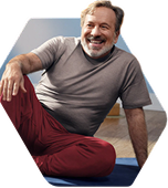 A man is sitting on the floor and smiling.